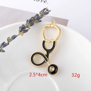 Close-up of golden stethoscope charm pendant with black enamel finish, size 2.5x4cm