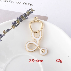 Detail of gold stethoscope pendant with white enamel, measuring 2.5x4cm for DIY jewelry