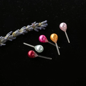 Conjunto de pendientes de perlas de resina multicolor sobre fondo de terciopelo negro