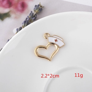 Detail of nurse hat heart pendant in white enamel and gold plating, 2.2x2cm size