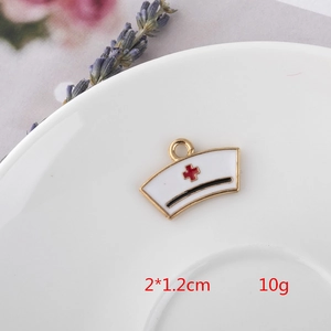 Detail of nurse cap enamel pendant in white and gold on a decorative white porcelain plate