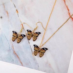 Detailed view of the orange butterfly jewelry set with necklace and hook earrings