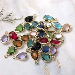Pendentifs en cristal multicolores en forme de goutte avec cadre doré sur marbre