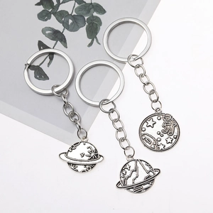 Vintage space themed metal keychains with planet and mountain charms in silver finish