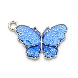 Detailansicht eines blauen Emaille-Schmetterlingsanhängers mit silbernem Glitzer für DIY-Schmuck