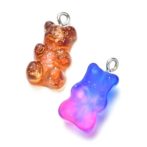 Detail of glitter resin gummy bear charms in yellow and purple for DIY jewelry