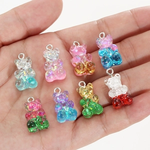 Colorful glitter gummy bear resin pendants for DIY jewelry making held in palm