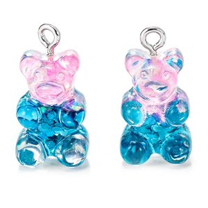 Macro detail of glittery resin gummy bear charms with pink and blue gradient