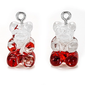 Detail of two resin bear pendants with red glitter filling and silver metal loops