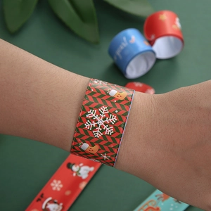 Close-up of red Christmas snap bracelet with snowflake and stocking patterns on wrist