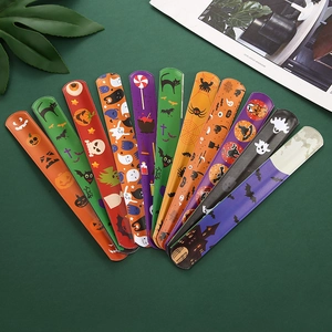 Collection of colorful Halloween slap bracelets with pumpkin and ghost patterns on dark green