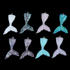 Macro shot of 8 colorful glittery resin mermaid tail pendants for DIY jewelry making