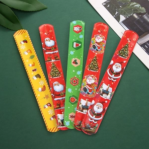 Flat lay of five festive Christmas slap bracelets with Santa and tree motifs on green backdrop