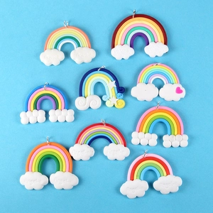 Macro detail of assorted colorful clay rainbow pendants with white clouds and silver rings