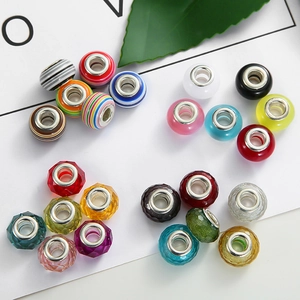 Macro display of assorted glass beads with large metal holes for DIY jewelry