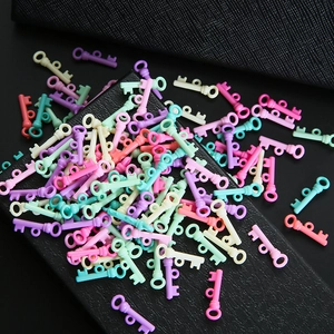Kleurrijke plastic sleutelhangers in macaron-kleuren voor DIY-sieraden op zwart leer