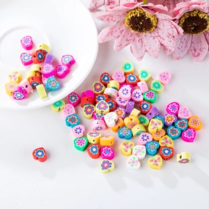 Gros plan de perles en pâte polymère en forme de cœur coloré avec motifs floraux pour DIY
