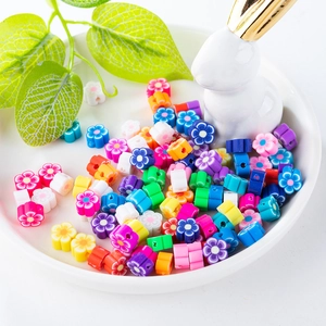 Perles de fleurs en pâte polymère colorée pour bijoux DIY dans un bol blanc