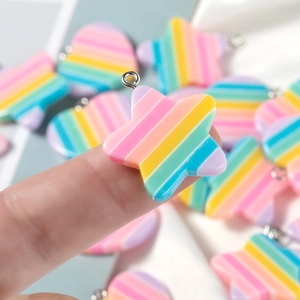 Macro view of rainbow resin star and heart charms with metal loops for DIY jewelry