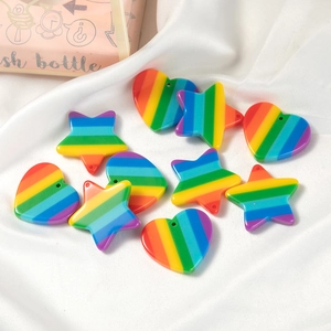 Rainbow striped heart and star resin pendants on white silk background for DIY jewelry