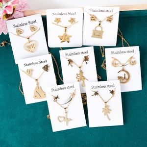 Golden stainless steel jewelry sets with Eiffel Tower and butterfly charms on velvet