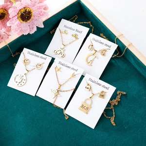Golden stainless steel jewelry set featuring Eiffel Tower and heart charms on display