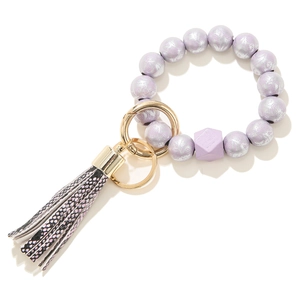 Detail of lavender wood beads with geometric accent and stylish snake print tassel charm