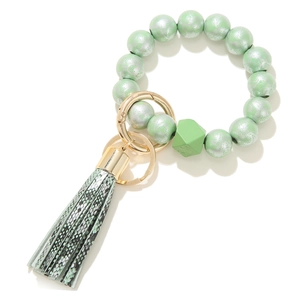 Detail view of green floral wood beads and snakeskin tassel on bracelet keychain