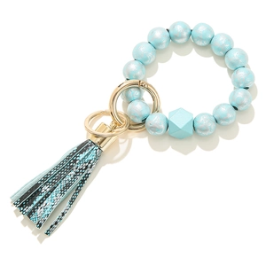 Detail of light blue beaded bracelet keychain with snakeskin print tassel and gold ring