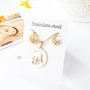 Macro detail of golden stainless steel jewelry set featuring Eiffel Tower silhouette