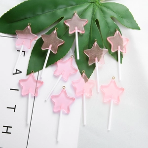 Macro detail van ster lolly hars bedeltjes in roze met glitter en gouden haken
