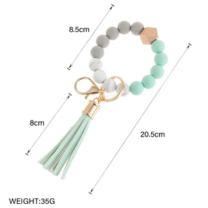 Detail of beaded keychain with mint green tassel, wood bead and marble silicone beads
