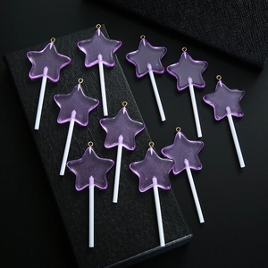 Detailopname van tien paarse hars ster lolly hangers met gouden metalen ophanglussen