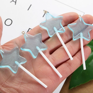 Gedetailleerd beeld van vier blauwe stervormige lolly hangers van hars met glitters en gouden ring