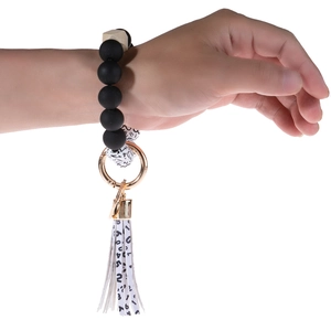 Dog paw cow pattern bead keychain bracelet with black beads and wooden tassel detail