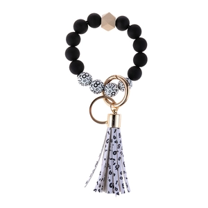 Black beaded keychain bracelet with cow print wooden bead and leather tassel charm