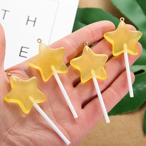 Macro-opname van vier gele hars ster lolly hangers voor handgemaakte sieraden