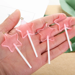 Detailopname van roze ster lolly bedeltjes van hars met oogjes voor DIY sieraden