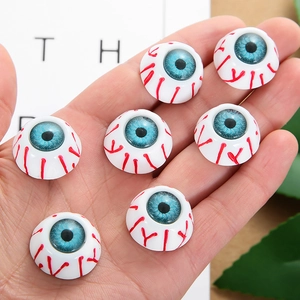 Detailed close-up of realistic bloodshot Halloween eyeballs held in a hand for scale