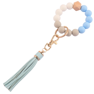 Detalle de pulsera de cuentas de silicona y madera con borla de cuero y cierre dorado