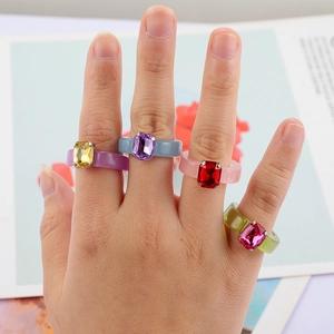 Close-up of four colorful resin rings with rectangular gemstones in candy colors