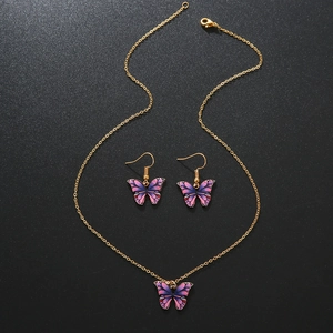 Set collana e orecchini con farfalle in lega dorata sfumata viola su sfondo nero