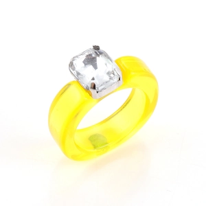 Macro shot of a yellow resin wide band ring featuring a large rectangular zircon stone