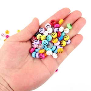 Main tenant des perles colorées avec sourire en résine pour bijoux DIY