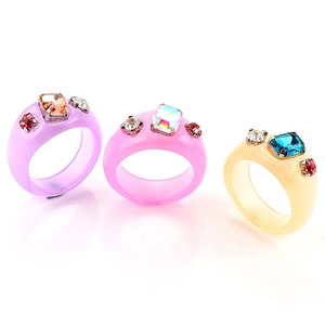 Vista macro de anillos de resina coloridos con diamantes incrustados estilo retro Y2K
