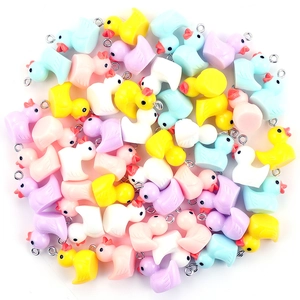Macro view of colorful resin mini duck pendants with metal hooks for DIY jewelry