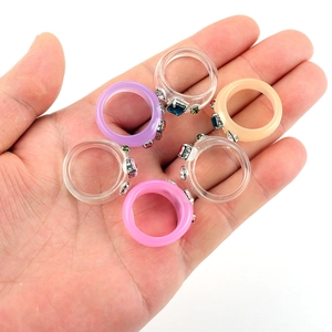 Detalle de seis anillos de resina coloridos con diamantes de imitación en la mano