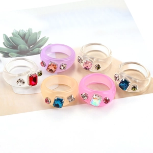 Primer plano de anillos de resina con diamantes rectangulares en varios colores pastel