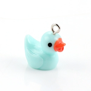 Macro shot of a light blue resin duck charm with a metal ring for DIY jewelry making