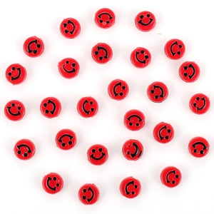 Détail de perles rouges en résine avec visage souriant pour création de bijoux DIY